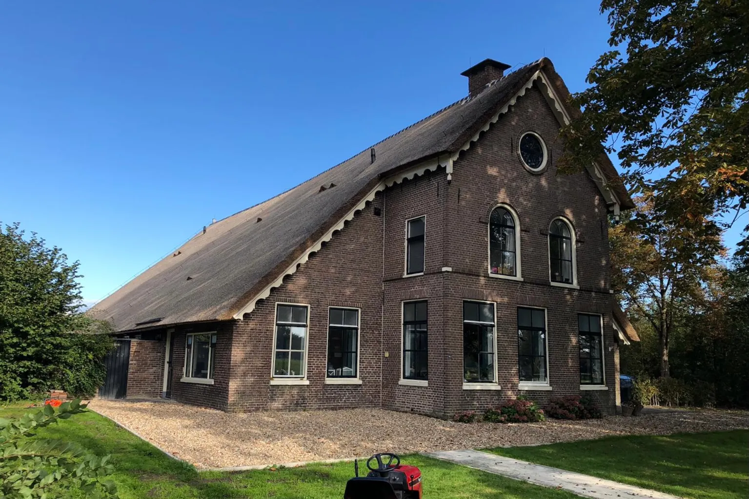 Het gebouw van Gezinshuis Dromelijn in Assen, een boerderij met rieten dak en bakstenen gevel