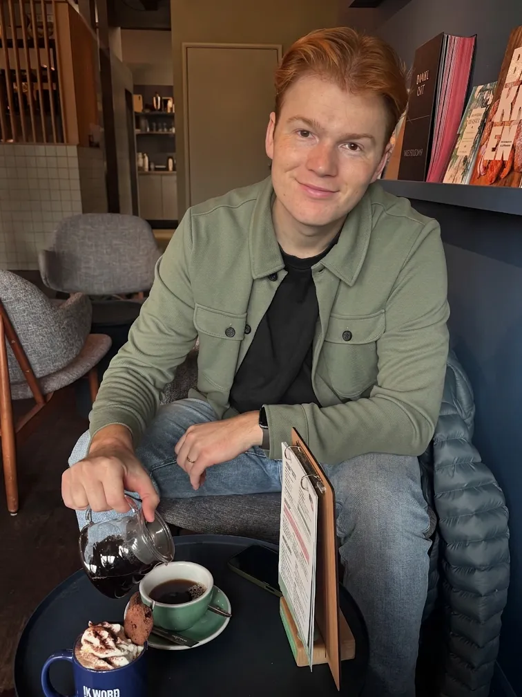 Rein Veenstra, eigenaar van Fixted, schenkt koffie in aan een tafeltje in een café